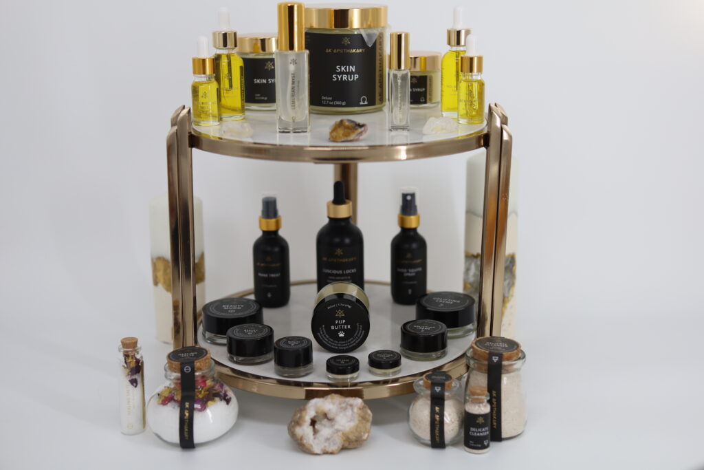 A complete selection of the products offered by AK Apothekary on a two layer set of gold and glass trays.