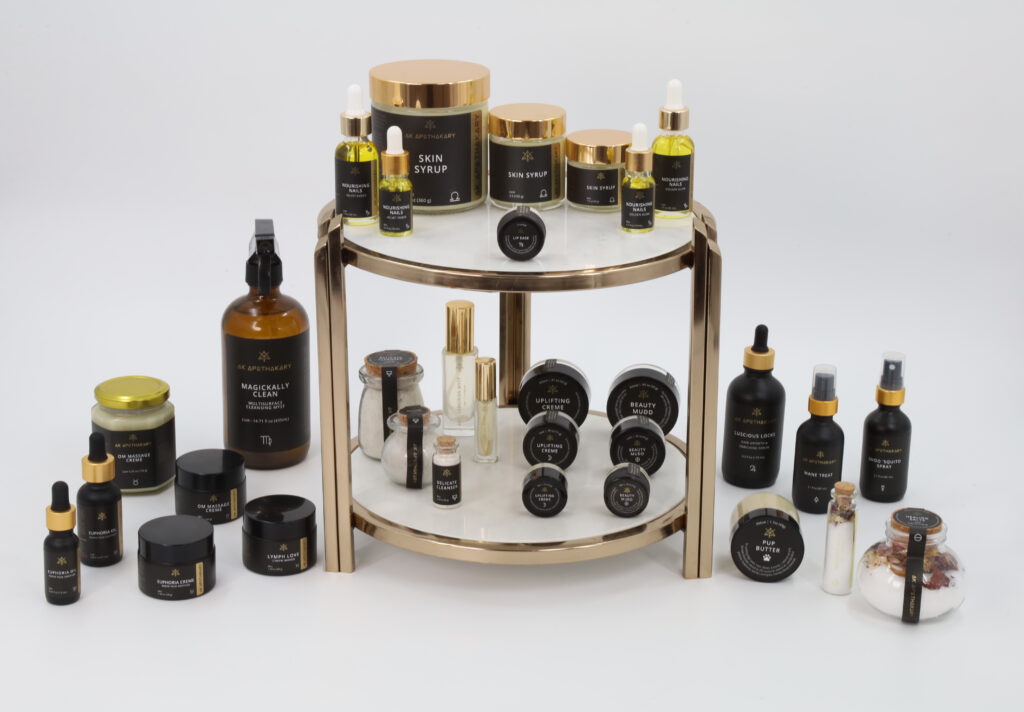 A complete selection of the products offered by AK Apothekary on a two layer set of gold and glass trays.